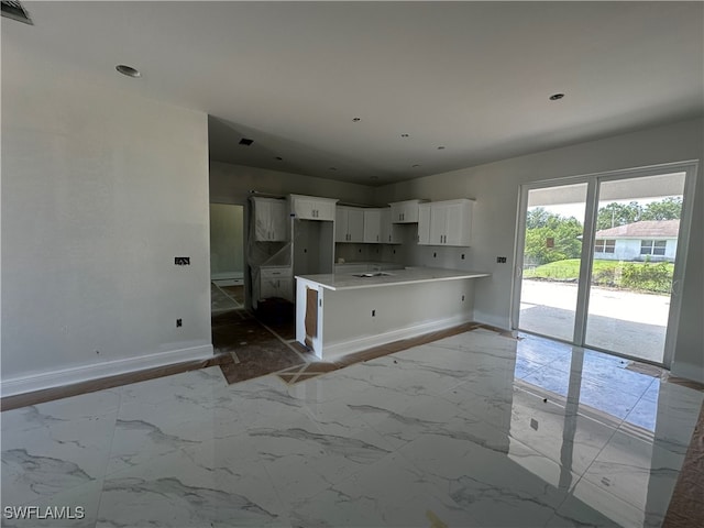 kitchen featuring light tile patterned flooring, kitchen peninsula, and white cabinetry