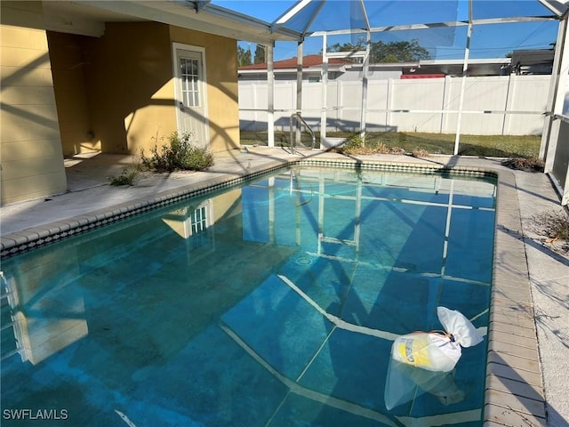 view of swimming pool featuring a lanai and a patio area