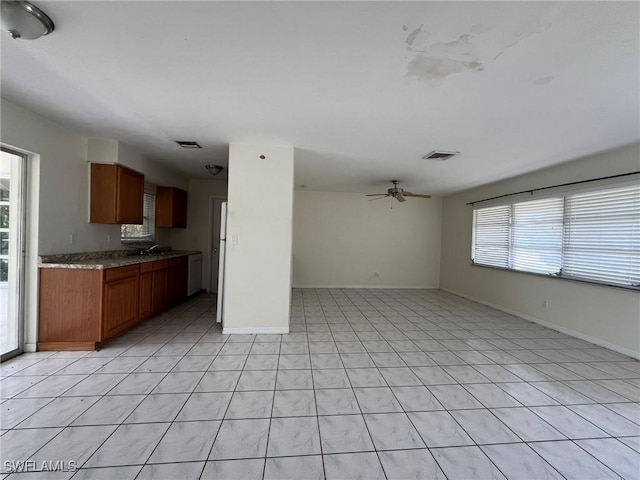 kitchen with white dishwasher, ceiling fan, light tile patterned flooring, and sink