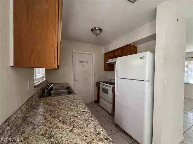 kitchen with sink, light tile patterned flooring, a healthy amount of sunlight, and white appliances