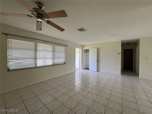 tiled spare room featuring ceiling fan