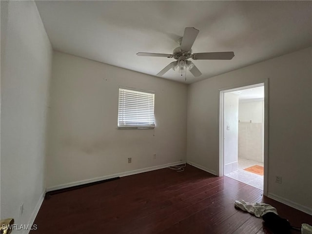 unfurnished room with ceiling fan and dark wood-type flooring