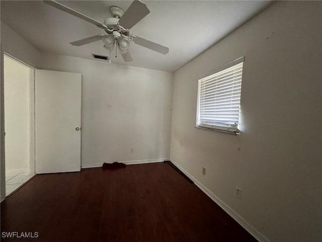 empty room with ceiling fan and dark wood-type flooring