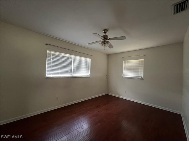 spare room with dark hardwood / wood-style floors and ceiling fan