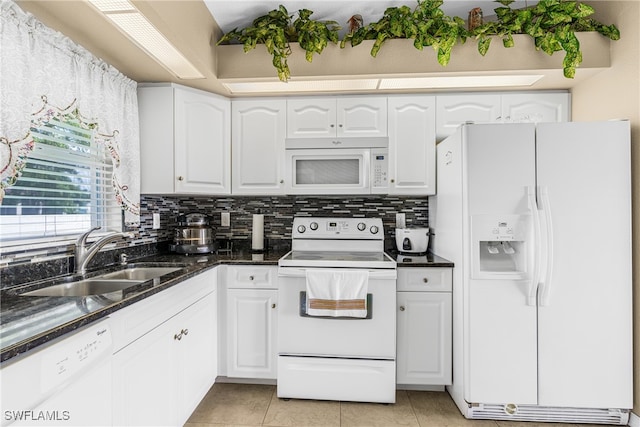 kitchen featuring white appliances, sink, light tile patterned floors, and white cabinets