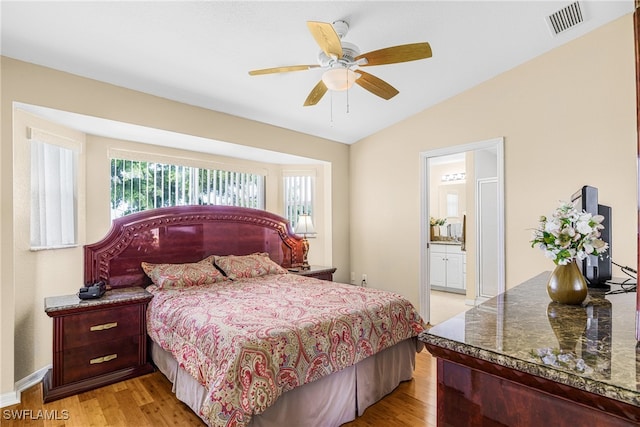 bedroom featuring lofted ceiling, connected bathroom, ceiling fan, and light hardwood / wood-style floors