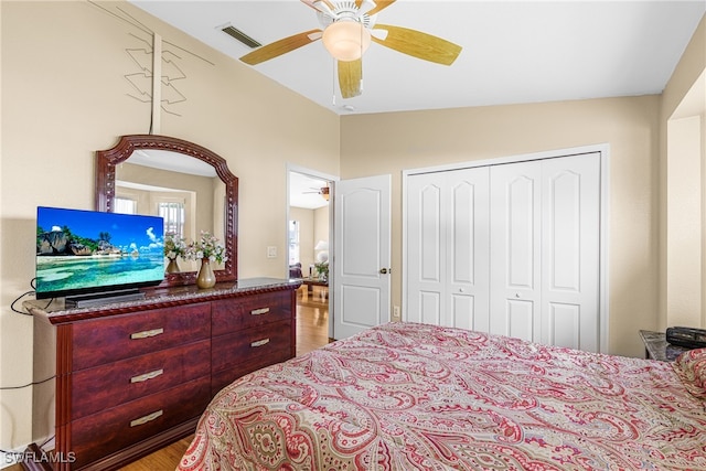 bedroom with light wood-type flooring, lofted ceiling, ceiling fan, and a closet