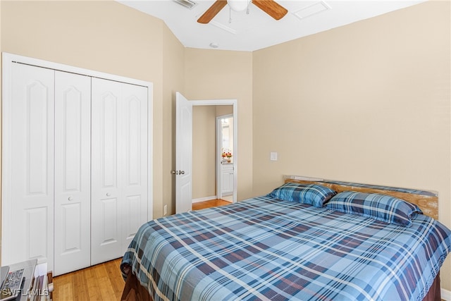 bedroom with light wood-type flooring, ceiling fan, and a closet