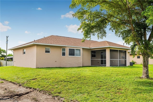 back of house featuring a lawn and a sunroom