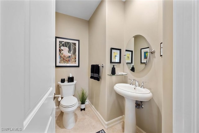 bathroom with toilet, tile patterned flooring, and baseboards