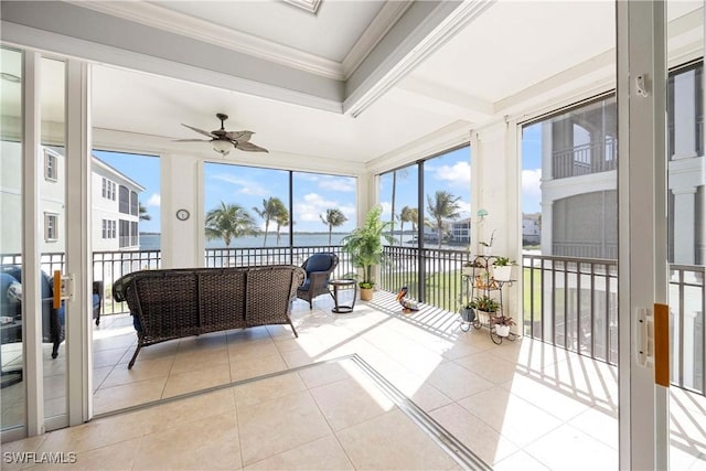 sunroom featuring a water view and a ceiling fan