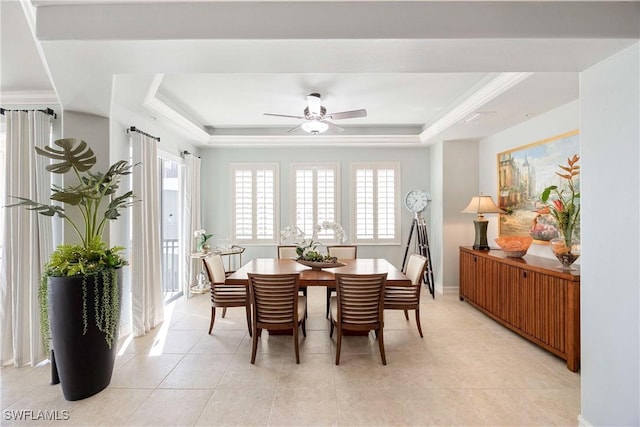 dining room featuring light tile patterned floors, a tray ceiling, a ceiling fan, and baseboards