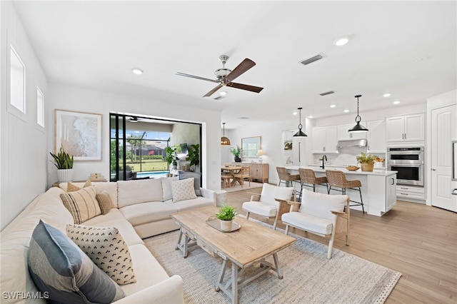 living room featuring light wood-type flooring and ceiling fan