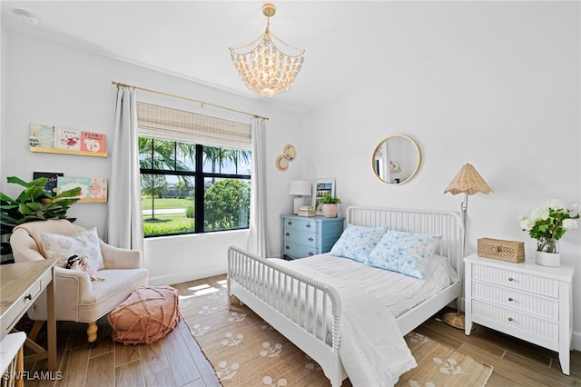 bedroom with an inviting chandelier and dark wood-type flooring