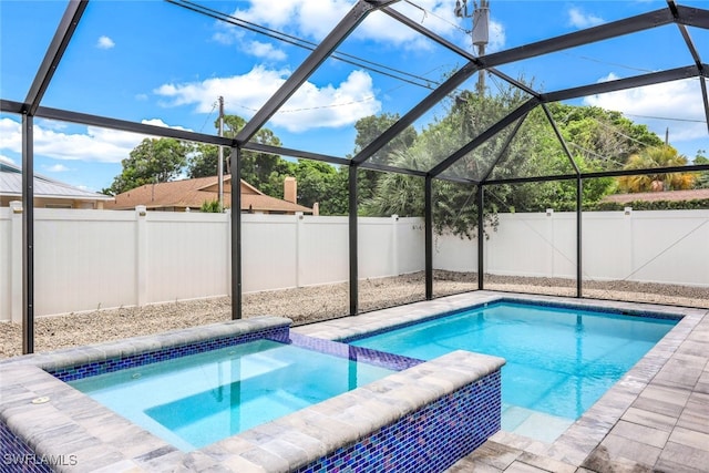 view of swimming pool featuring a lanai and an in ground hot tub