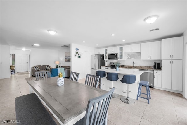 dining area with light tile patterned floors and sink