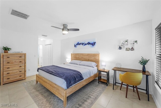 tiled bedroom featuring ensuite bathroom and ceiling fan