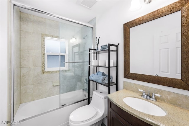 full bathroom featuring toilet, combined bath / shower with glass door, and vanity