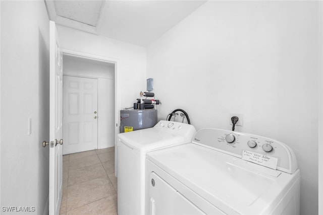 laundry room featuring light tile patterned floors, gas water heater, and washing machine and clothes dryer