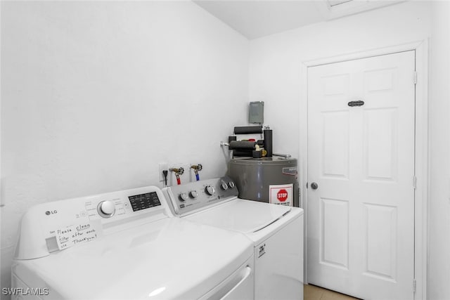 clothes washing area with separate washer and dryer and water heater