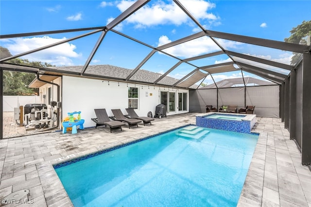 view of swimming pool with an in ground hot tub, a patio, area for grilling, and a lanai