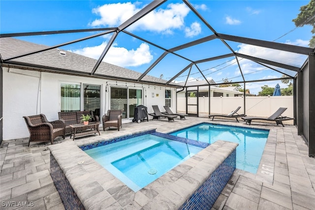 view of pool with glass enclosure, an in ground hot tub, a patio, and an outdoor hangout area