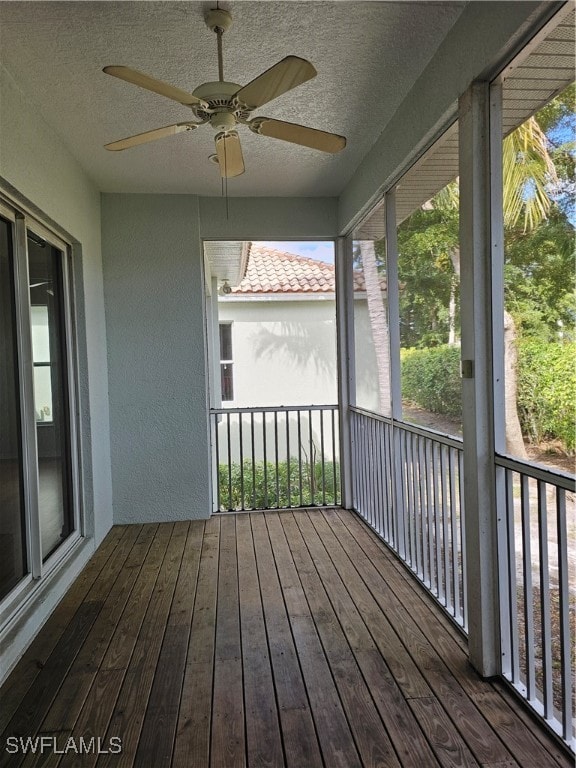 unfurnished sunroom featuring ceiling fan