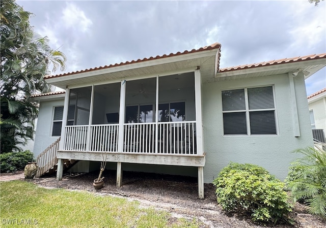 rear view of house featuring a sunroom