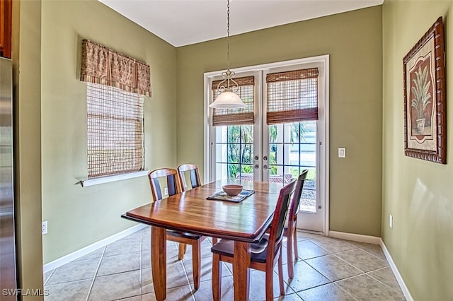 tiled dining space featuring french doors