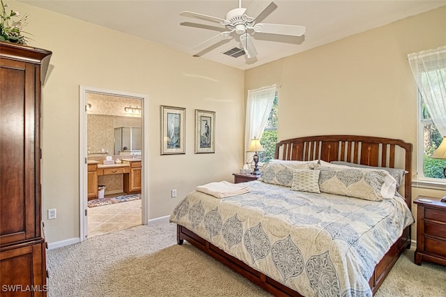 bedroom featuring light colored carpet, connected bathroom, and ceiling fan