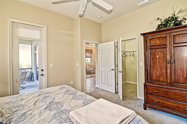 bedroom featuring light colored carpet, ceiling fan, and a closet