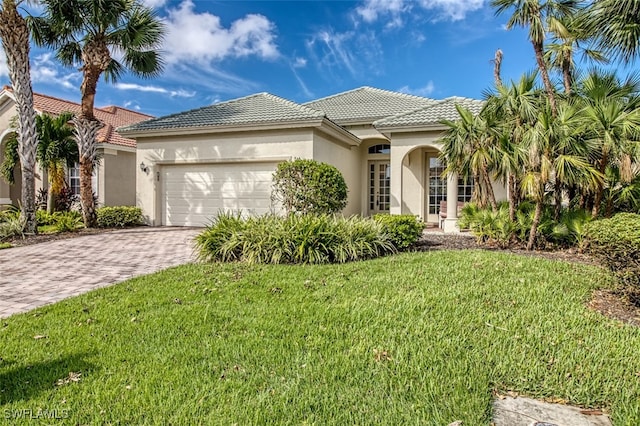 mediterranean / spanish-style house with a front lawn and a garage