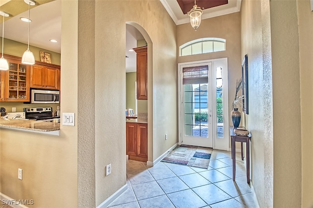 tiled entrance foyer featuring plenty of natural light and crown molding