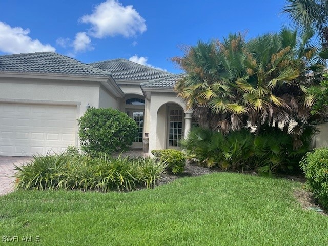 view of front of house featuring a garage and a front lawn