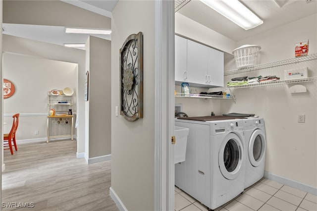 laundry room featuring cabinets, light hardwood / wood-style flooring, and independent washer and dryer