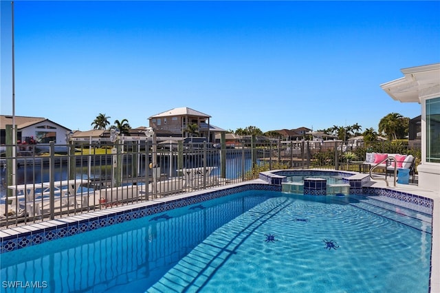 view of swimming pool with an in ground hot tub and a water view