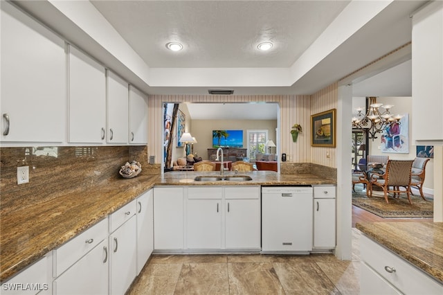 kitchen with sink, white cabinetry, white dishwasher, and dark stone counters