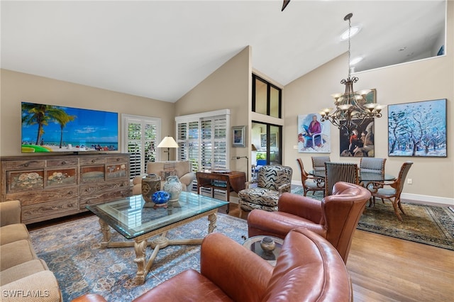 living room with high vaulted ceiling, wood-type flooring, and an inviting chandelier