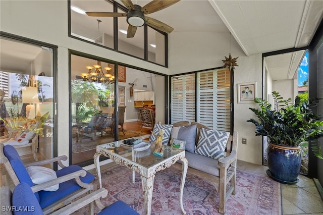 sunroom / solarium featuring ceiling fan with notable chandelier and lofted ceiling