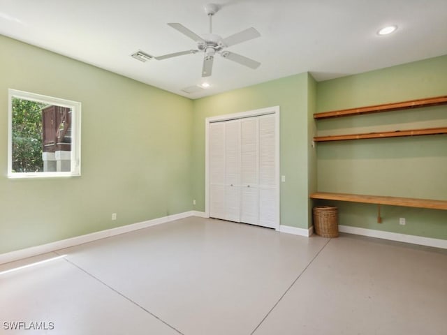 unfurnished bedroom featuring a closet, baseboards, concrete flooring, and recessed lighting