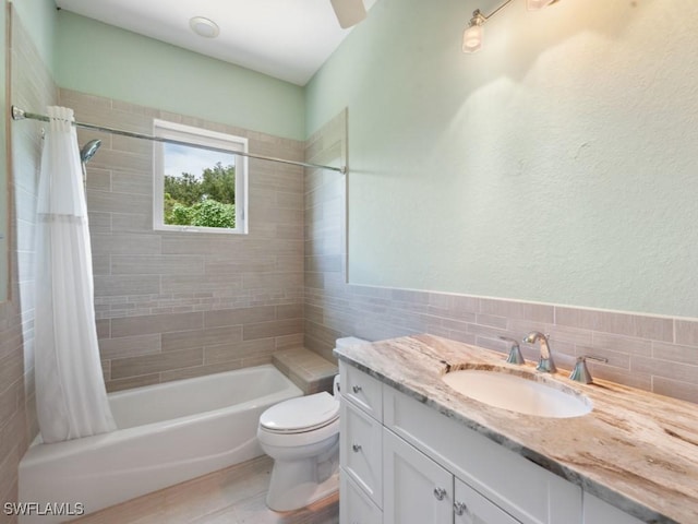 full bathroom featuring tile walls, vanity, toilet, and shower / bathtub combination with curtain