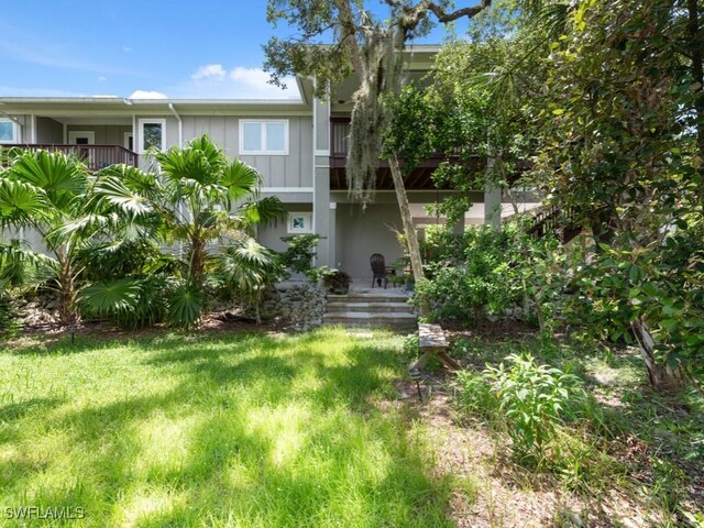 exterior space featuring a lawn and a balcony