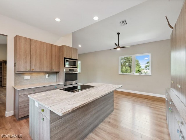 kitchen featuring visible vents, appliances with stainless steel finishes, backsplash, a center island, and brown cabinetry