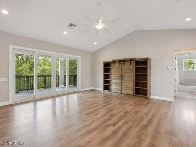 unfurnished living room with lofted ceiling, visible vents, baseboards, a ceiling fan, and light wood-type flooring