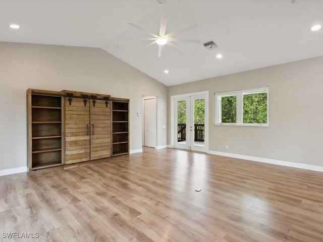 interior space featuring light wood-style floors, french doors, visible vents, and vaulted ceiling