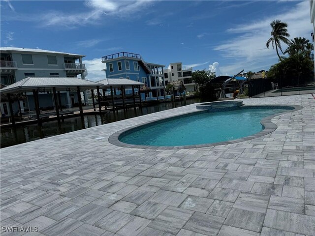 view of pool featuring a gazebo, a water view, an in ground hot tub, and a patio