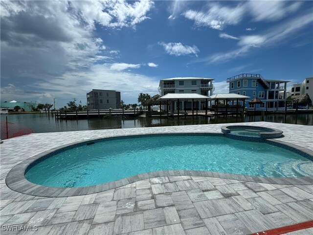 view of pool with a gazebo, a water view, and an in ground hot tub