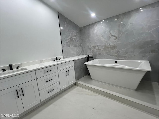 bathroom featuring vanity, a bathtub, and tile walls