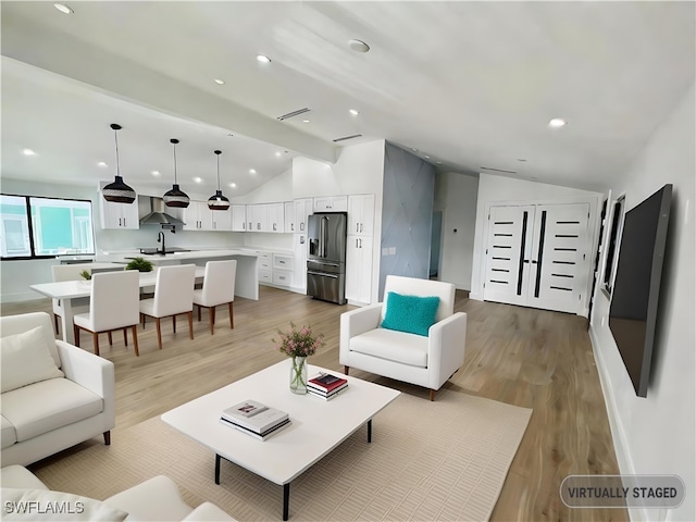 living room with lofted ceiling with beams and light wood-type flooring