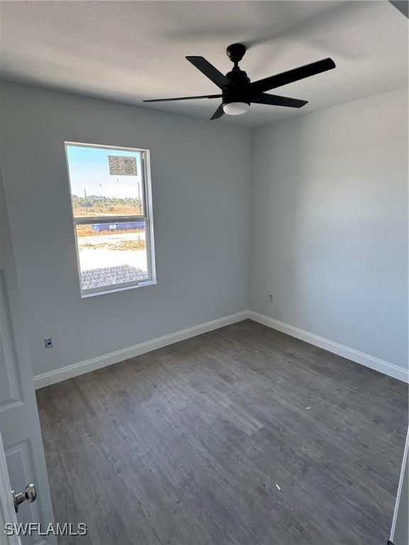 spare room featuring dark hardwood / wood-style floors and ceiling fan